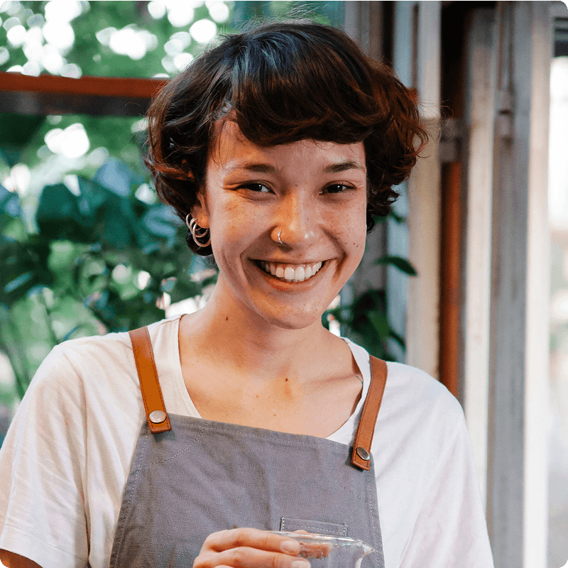 Smiling server in an apron and white T-shirt